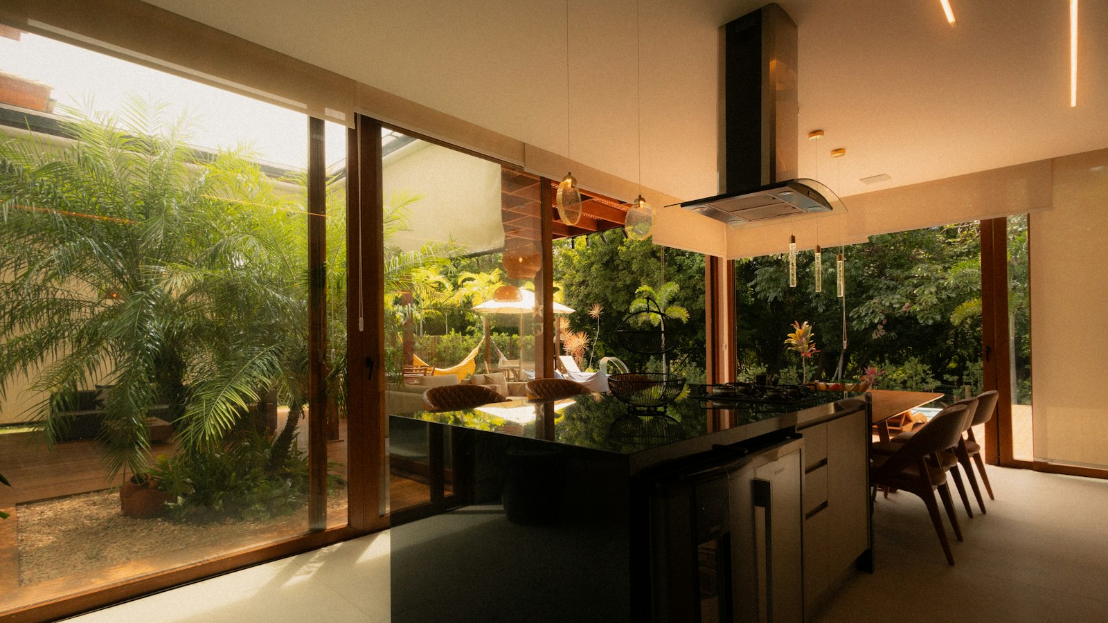 Cozinha moderna com ilha e vista para jardim em casa de campo